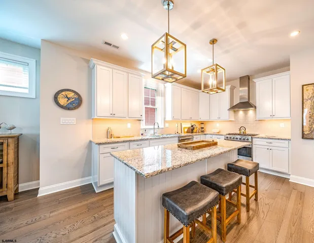 a kitchen with a sink dishwasher a stove and a refrigerator with wooden floor