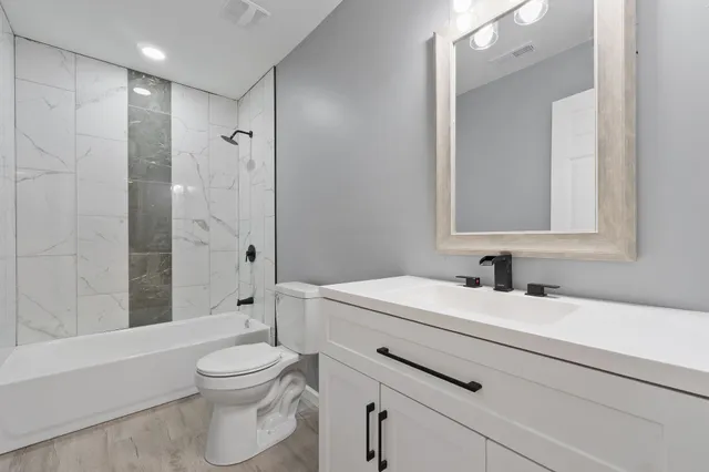 a bathroom with a sink toilet vanity and shower