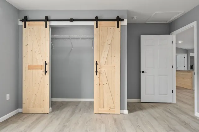 an empty room with wooden floor and a bathroom