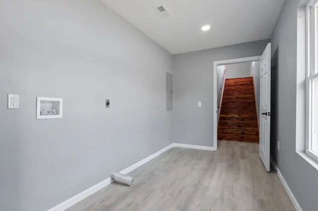 an empty room with windows and ceiling fan