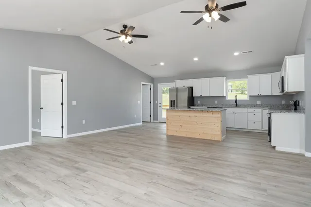 a view of kitchen with cabinets microwave and stove