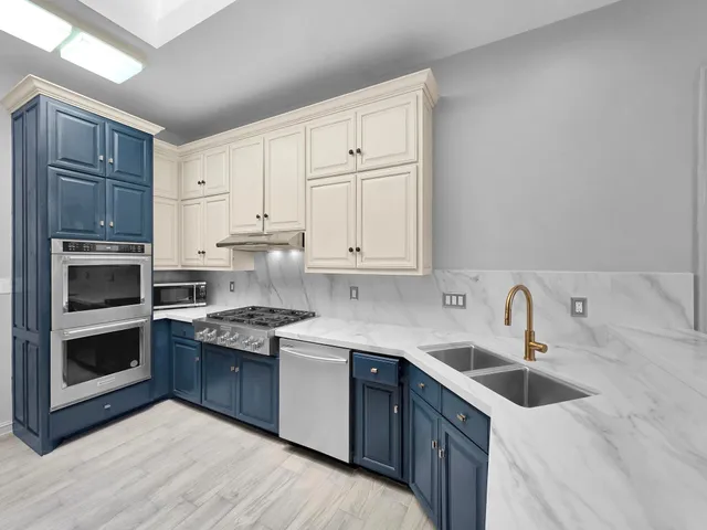 a large white kitchen with a sink and cabinets