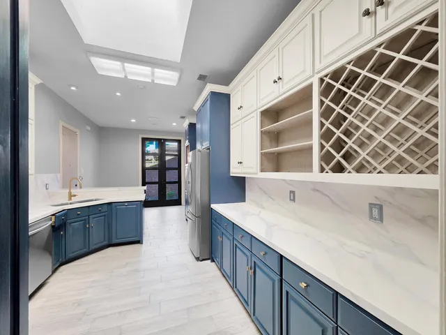 a kitchen with stainless steel appliances kitchen island granite countertop a refrigerator stove and sink