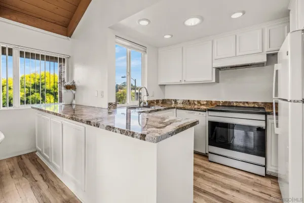 a kitchen with granite countertop a sink stainless steel appliances and cabinets