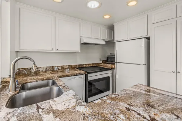 a kitchen with stainless steel appliances granite countertop a sink stove and refrigerator
