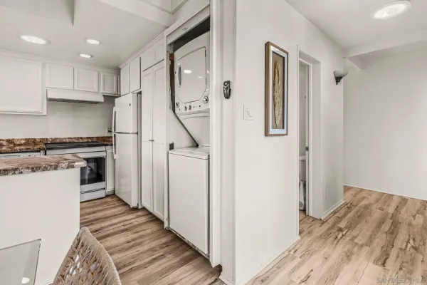 a view of a kitchen with a white cabinets and wooden floor