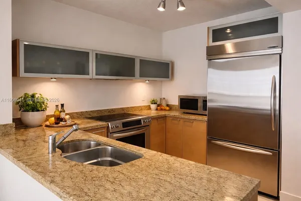 a kitchen with stainless steel appliances granite countertop a refrigerator and a sink