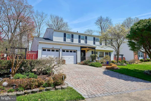 a front view of a house with a yard and potted plants