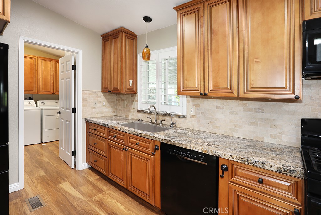 61 Saddleback Road Tustin, CA 92780 - Photo 12 of 49 a kitchen with stainless steel appliances granite countertop wooden cabinets a sink and a large window
