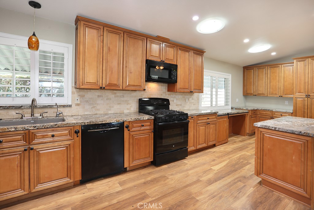 61 Saddleback Road Tustin, CA 92780 - Photo 15 of 49 a kitchen with stainless steel appliances granite countertop wooden cabinets a stove a sink and a window