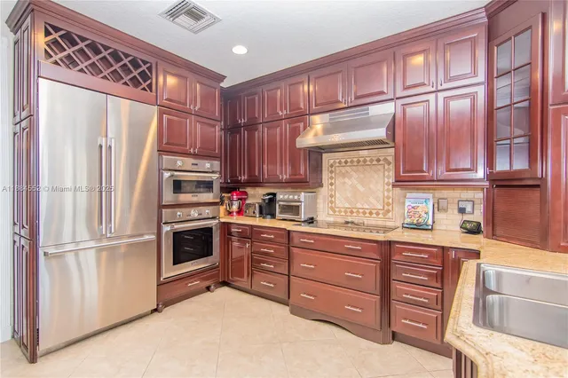 a kitchen with stainless steel appliances granite countertop a refrigerator sink and cabinets