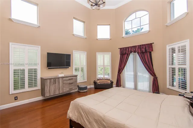 a spacious bedroom with a bed and wooden floor