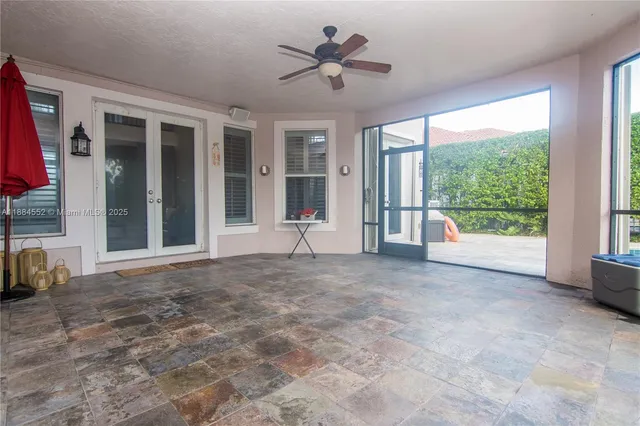 a view of a livingroom with a flat screen tv wooden floor and a ceiling fan