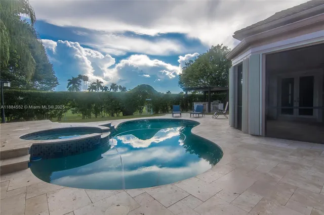 a view of a white house with a small yard and a large tree