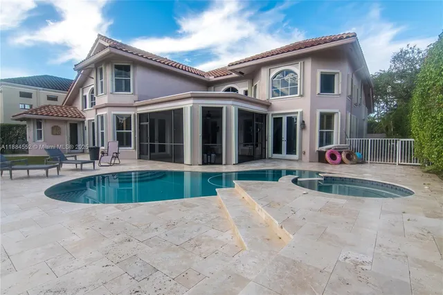 a front view of a house with a garden and trees