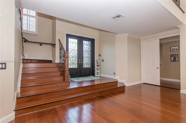 a view of front door with wooden floor and stairs