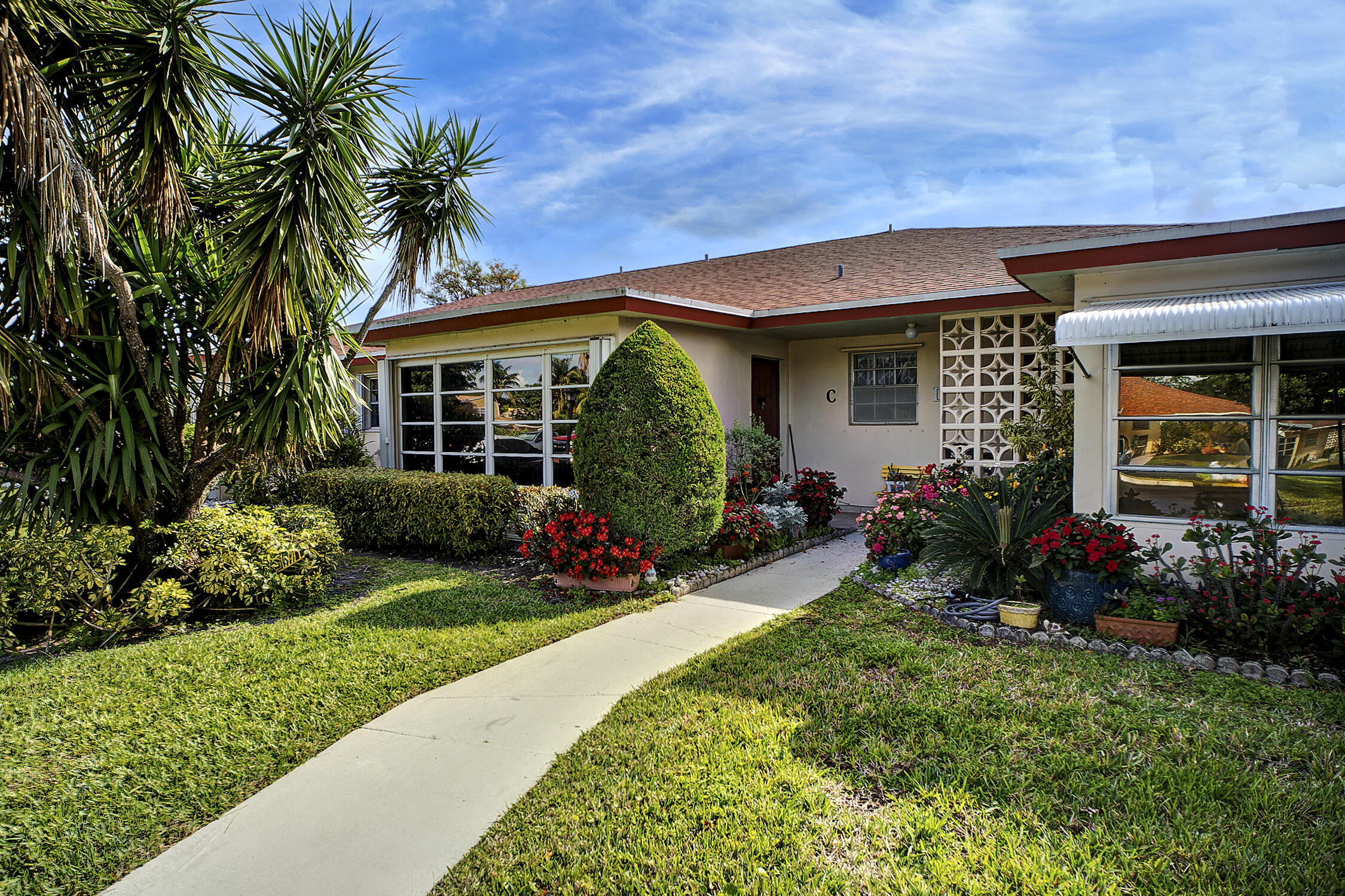 4810 Northwest 4th Street, Unit C Delray Beach, FL 33445 - Photo 1 of 35 a front view of a house with a garden