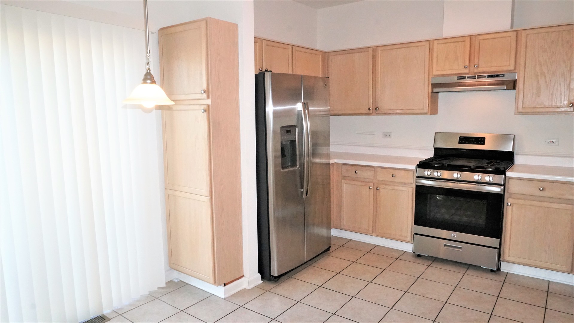 3360 Ravinia Circle Aurora, IL 60504 - Photo 7 of 32 a kitchen with white cabinets and stainless steel appliances