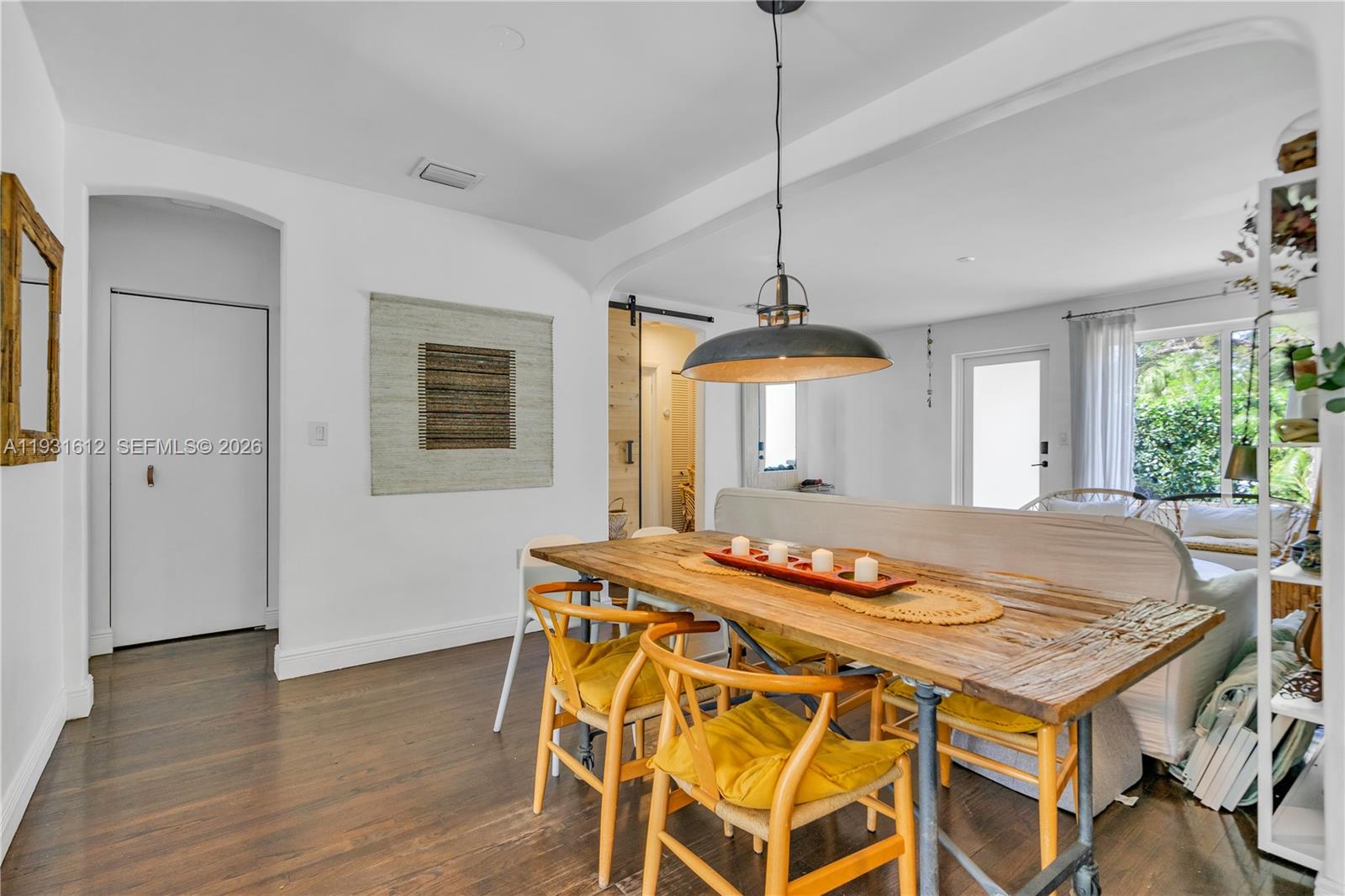 419 Southwest 30th Road Miami, FL 33129 - Photo 8 of 22 a dining room with wooden floor a chandelier a wooden table and chairs