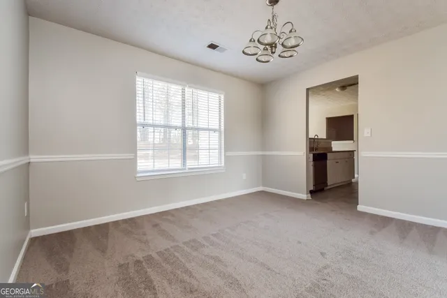 a view of a big room with windows and chandelier