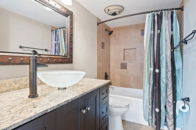 a bathroom with a granite countertop sink toilet and shower
