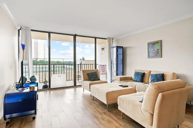 a living room with furniture and a large window with balcony view
