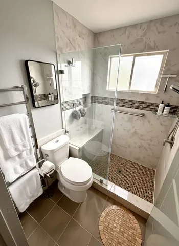 a bathroom with a toilet mirror vanity and window