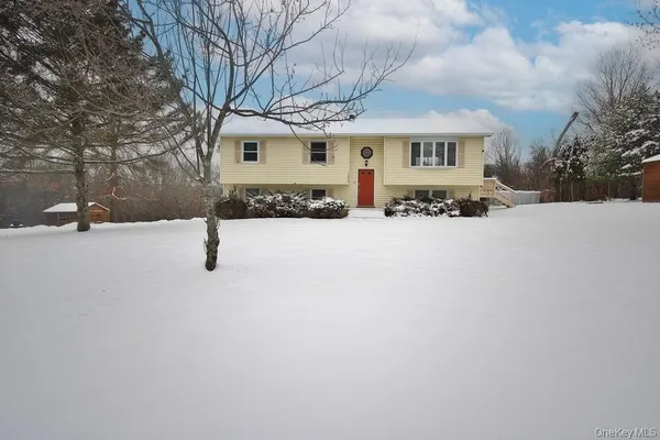 an outdoor view of house with backyard and parking