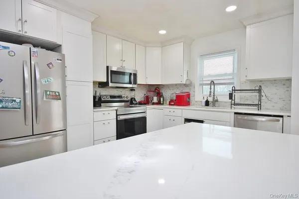 a kitchen with granite countertop stainless steel appliances and refrigerator