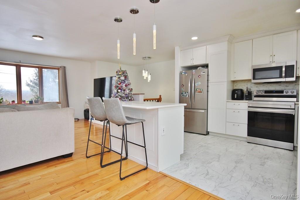 1065 Dolsontown Road Middletown, NY 10940 - Photo 50 of 50 a kitchen with stainless steel appliances kitchen island granite countertop a refrigerator a stove a sink dishwasher and white cabinets with wooden floor
