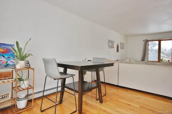 a kitchen with stainless steel appliances kitchen island granite countertop a refrigerator a stove a sink dishwasher and white cabinets with wooden floor