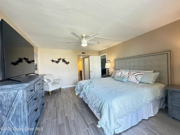 a bedroom with a bed and a flat tv screen on dresser