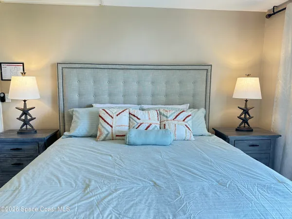 a spacious bedroom with a bed and a lamp