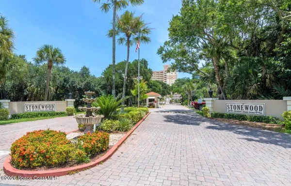a view of a park with potted plants and large trees
