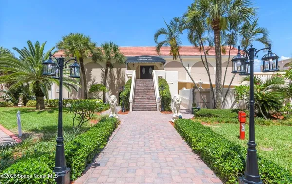 a front view of a house with a yard and potted plants