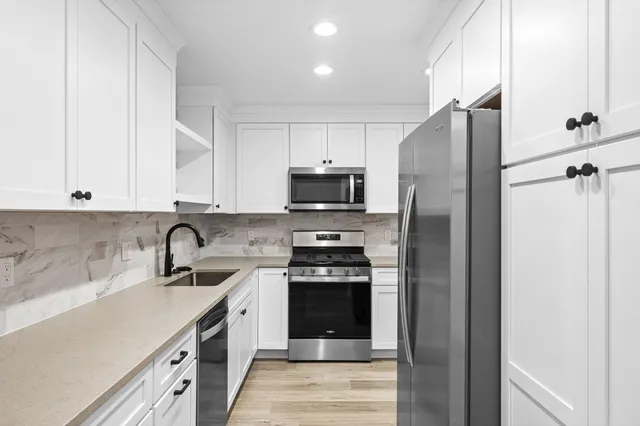 a kitchen with stainless steel appliances granite countertop a refrigerator and a sink