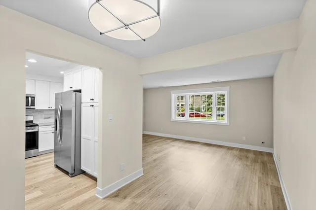 a view of kitchen with stainless steel appliances granite countertop a refrigerator and a stove top oven