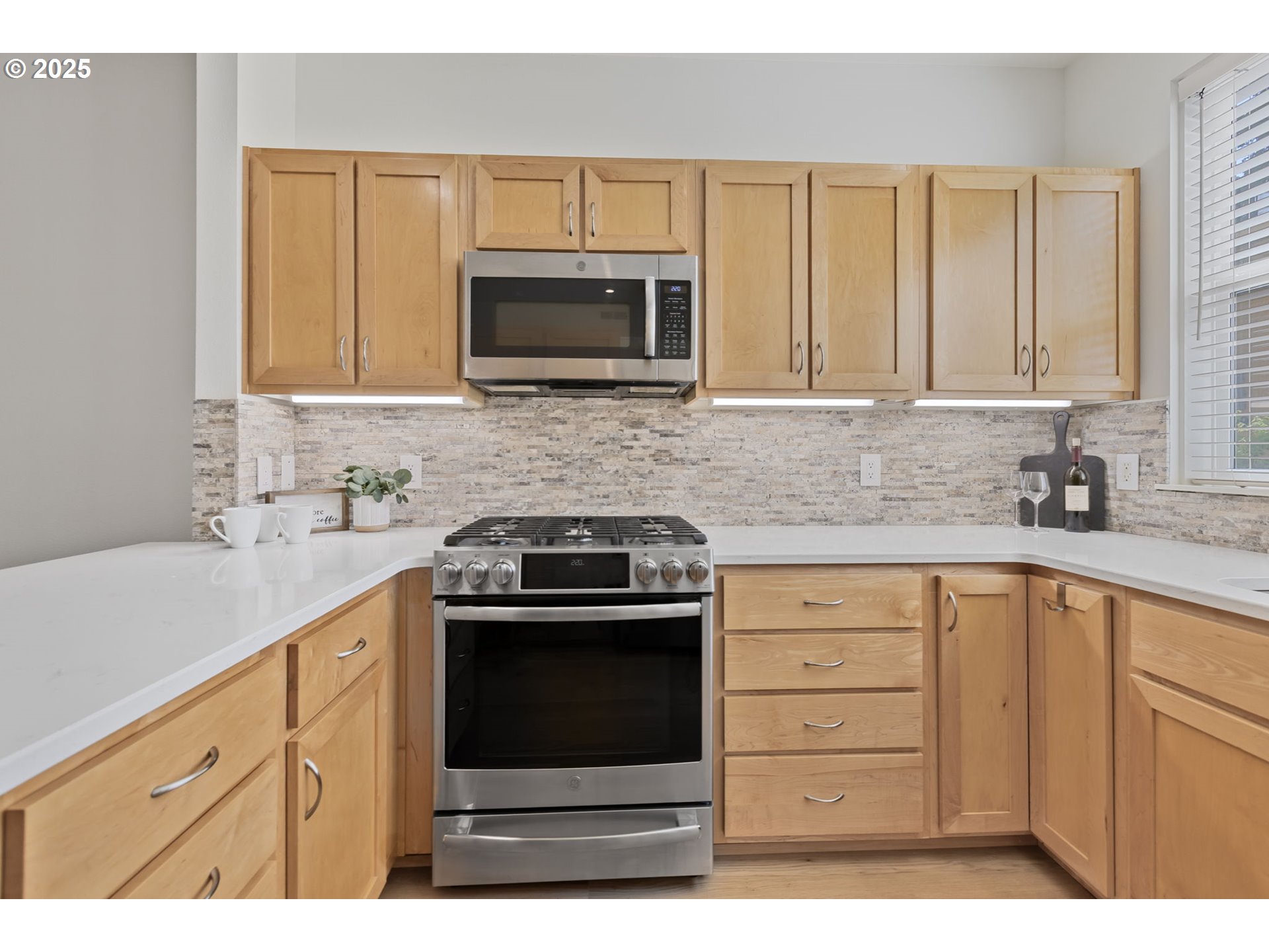 347 Rustic Place, Unit 24 Eugene, OR 97401 - Photo 15 of 42 a kitchen with stainless steel appliances granite countertop white cabinets a microwave oven a sink and a white refrigerator