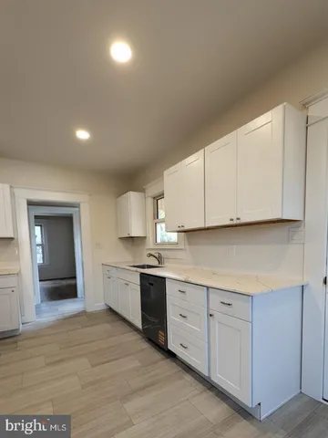 a kitchen with granite countertop white cabinets and white appliances