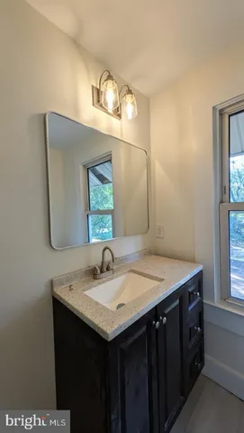 a bathroom with a sink vanity and a mirror