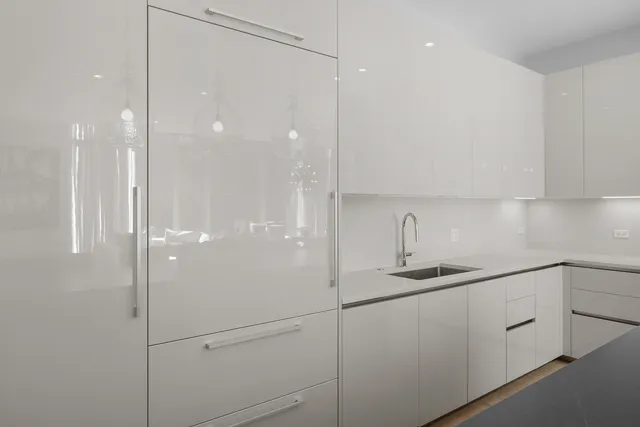 a large kitchen with kitchen island a large counter top space a sink stainless steel appliances and cabinets