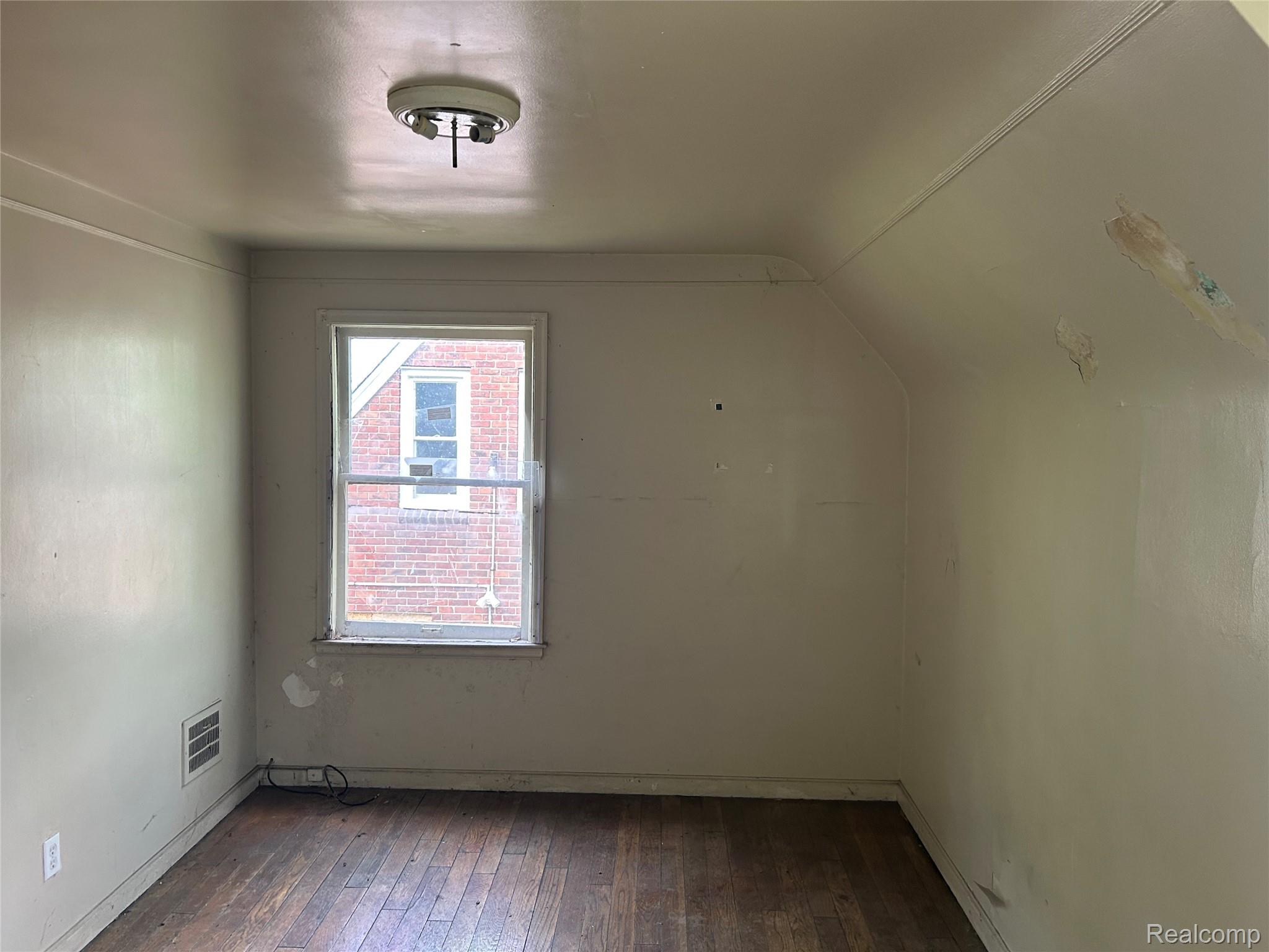 12641 Kelly Road Detroit, MI 48224 - Photo 27 of 40 Room featuring a single-pane window, wood-finish flooring, and sloped ceiling