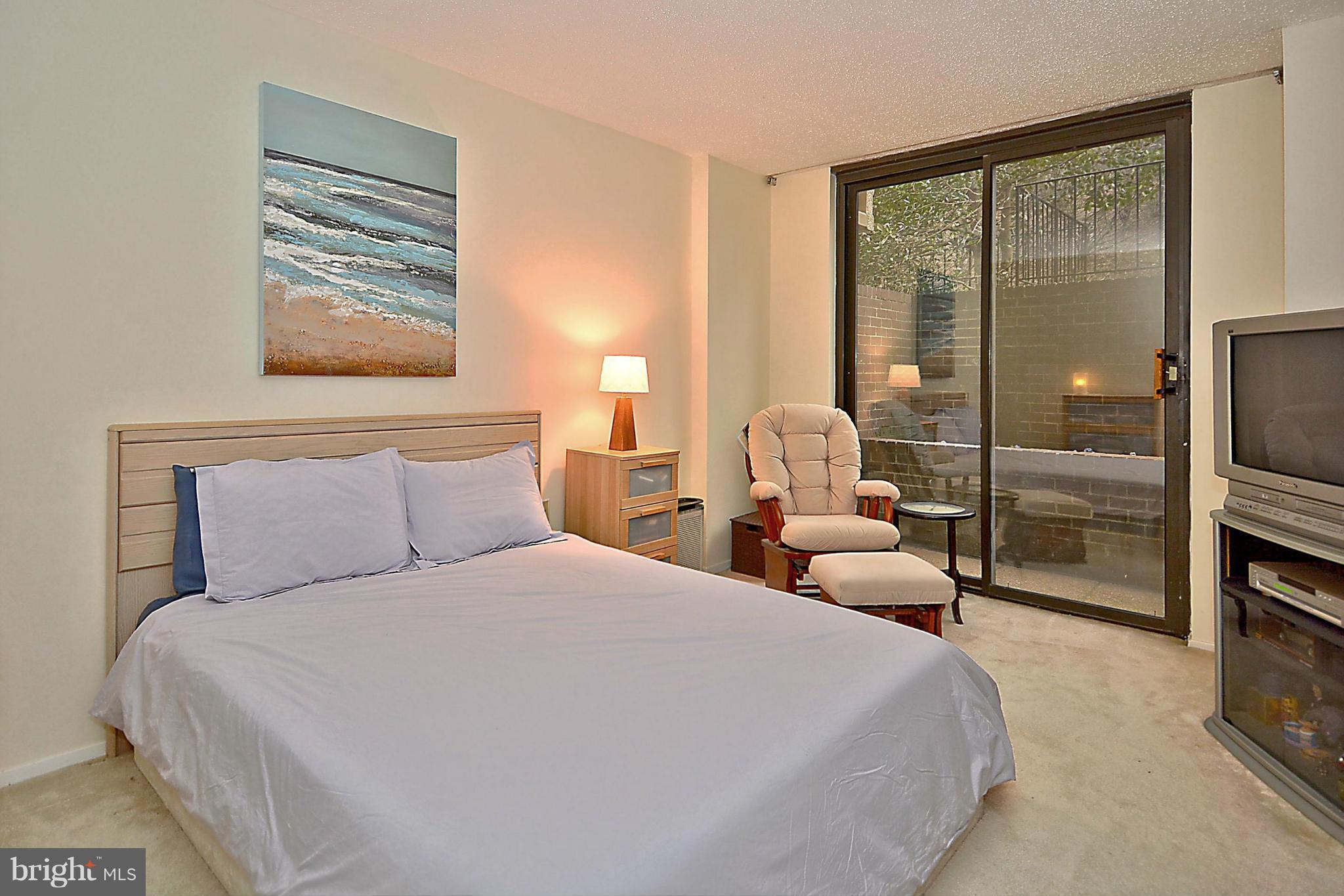 1808 Old Meadow Road, Unit 217 McLean, VA 22102 - Photo 10 of 30 a bedroom with a large bed and a tv