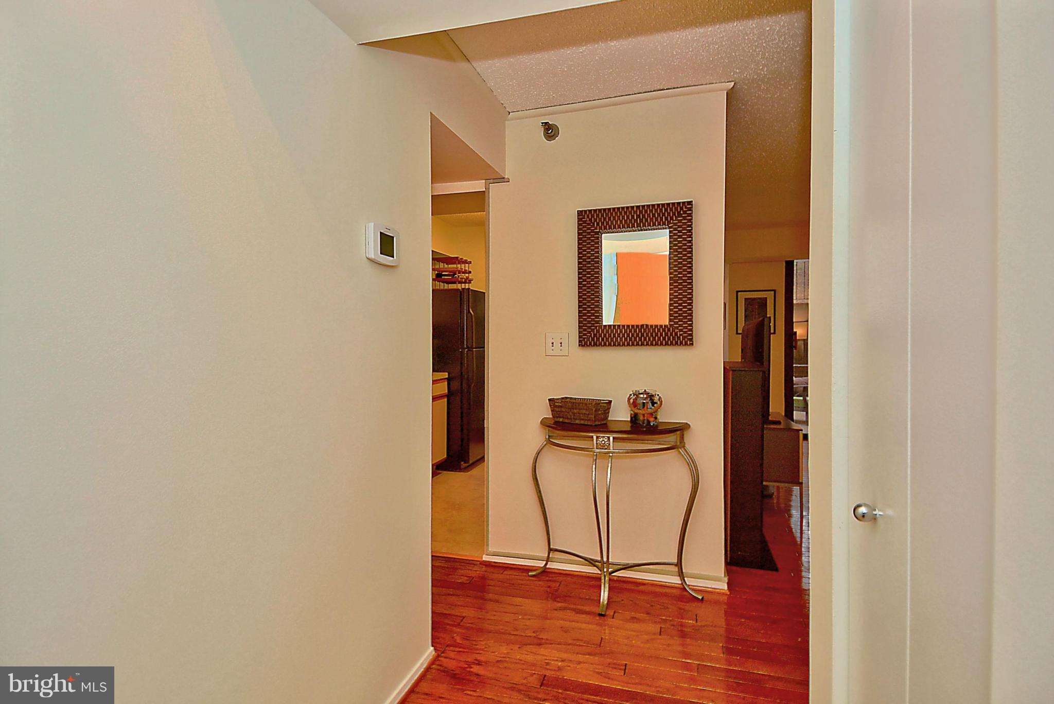 1808 Old Meadow Road, Unit 217 McLean, VA 22102 - Photo 8 of 30 a view of a livingroom with a chair and mirror