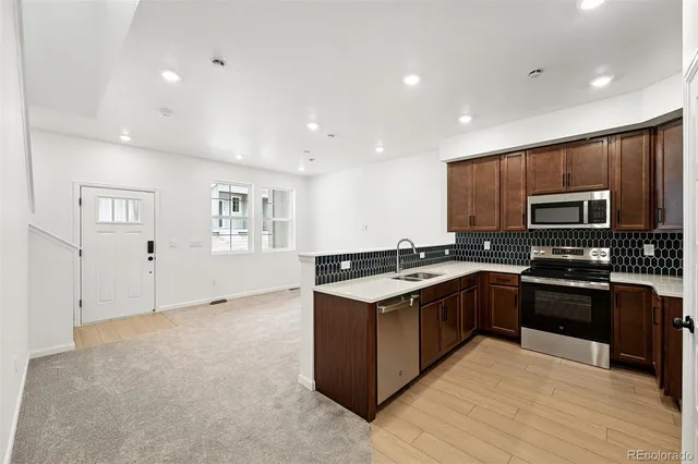 a large kitchen with stainless steel appliances granite countertop a stove and a sink