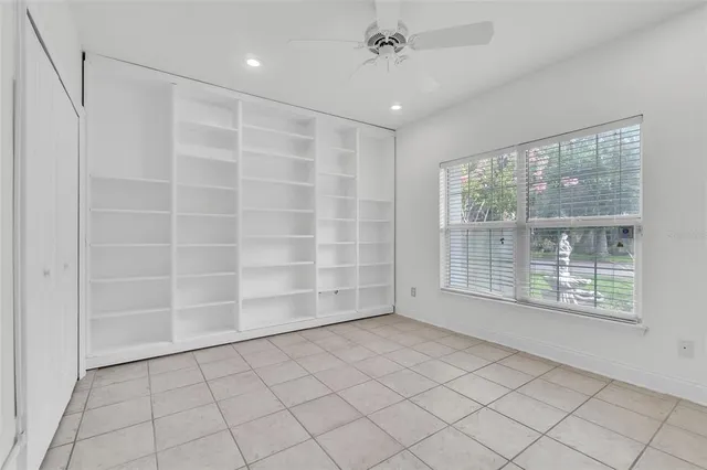 a spacious bedroom with a bed and a lamp