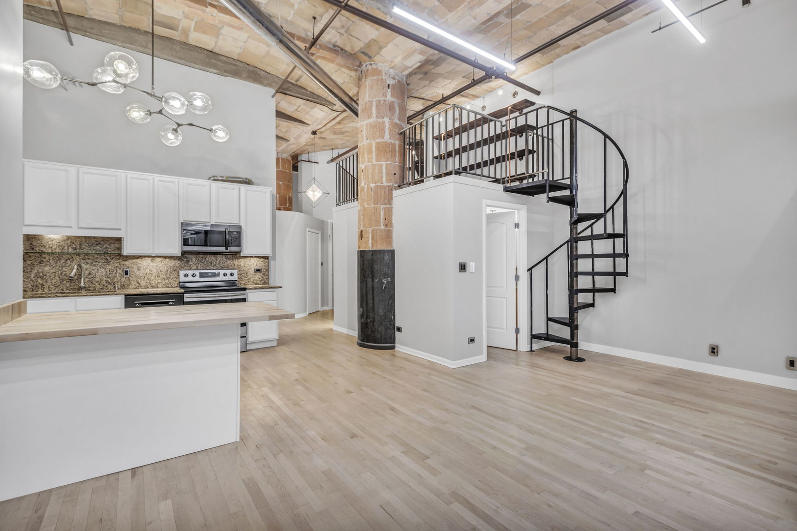 801 South Wells Street, Unit 101 Chicago, IL 60607 - Photo 5 of 33 a view of a kitchen with wooden floor and electronic appliances