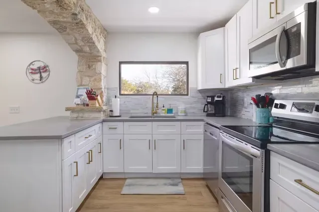a kitchen with white cabinets and white appliances