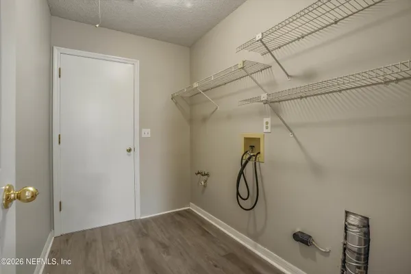an empty room with a chandelier fan and windows