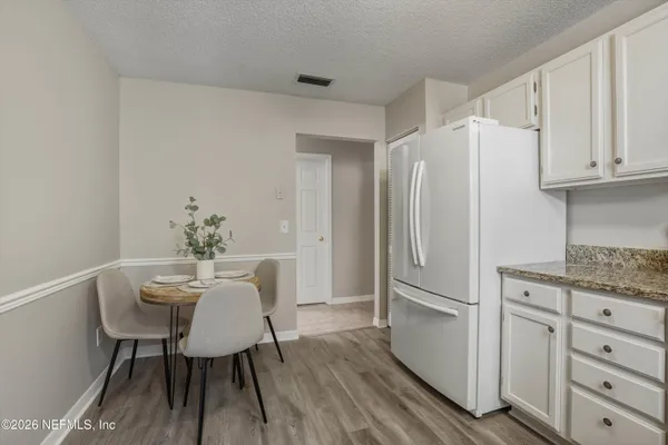 a kitchen with white cabinets and white appliances
